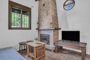 a living room with a fireplace and a television at Casas al Alba 2 in Zahora