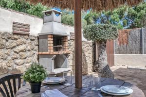 an outdoor table with a pizza oven on a stone wall at Casas al Alba 2 in Zahora