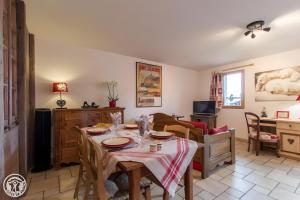 a living room with a table and a dining room at Gîte Chez Mayon in Orcier