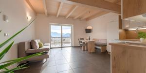 a kitchen and living room with a couch and a table at Kardonighof Kaltern in Caldaro