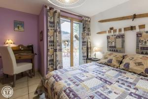 a bedroom with a bed and a desk and a window at Gîte Chez Mayon in Orcier