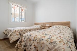 a bedroom with two beds and a window at Ca La Lola in Llorenç del Penedes