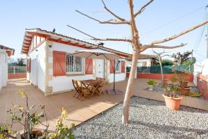 a patio with a table and an umbrella at Ca La Lola in Llorenç del Penedes