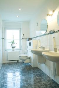 baño con 2 lavabos, aseo y ventana en Tilla's Hof, en Hamm