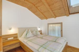 a large bed in a bedroom with a wooden ceiling at Moarhof in Rosa
