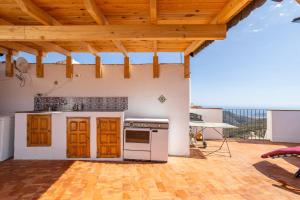 a kitchen with a stove and a wooden ceiling at Zarzamora de Rubite in Rubite