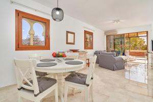 a dining room and living room with a table and chairs at Apartamento Ombú in La Herradura