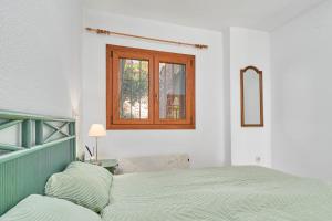 a bedroom with a bed and a window at Apartamento Ombú in La Herradura