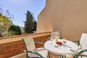 a table with two glasses of wine on a patio at Apartamento Ombú in La Herradura