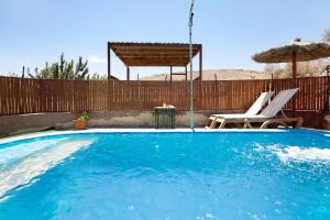a swimming pool with a chair and an umbrella at Esencia Eco-rústico Adults Only in El Charco