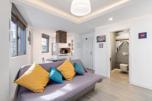 a living room with a gray couch with yellow and blue pillows at Ínsula Home in Tamaraceite