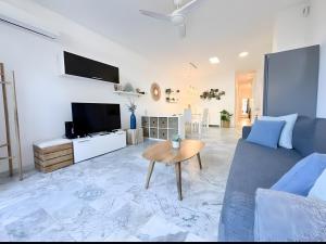 a living room with a blue couch and a tv at Ola De Mar - Estepona in Estepona