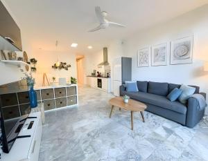 a living room with a blue couch and a table at Ola De Mar - Estepona in Estepona