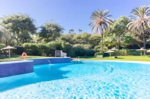 a swimming pool in a resort with palm trees at Ola De Mar - Estepona in Estepona