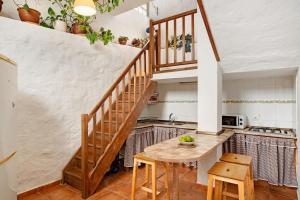 a kitchen with a wooden table and a staircase at Mirador de la Abuela in Gáldar