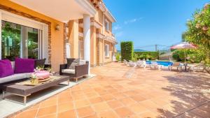 a patio with a couch and a table and chairs at Costacabana - Villa Primavera in Lloret de Mar