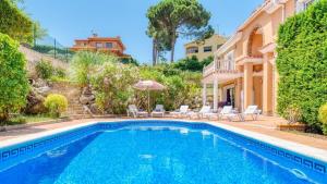 a villa with a swimming pool and a house at Costacabana - Villa Primavera in Lloret de Mar
