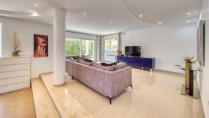 a living room with a couch and a tv at Costacabana - Villa Primavera in Lloret de Mar