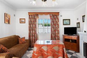 a living room with a couch and a tv at Villa Carmen in Hozanejos