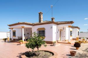 a small white house with a tree in a courtyard at Villa Carmen in Hozanejos
