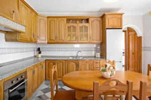 a kitchen with wooden cabinets and a wooden table at Villa Carmen in Hozanejos