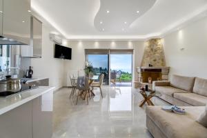 a kitchen and living room with a couch and a table at Goudis Villa Thanasis in Lefkada
