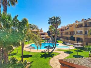 an apartment complex with a swimming pool and palm trees at Albatros Playa 3 - 1207 in Mar de Cristal