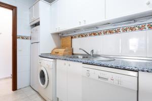 a white kitchen with a sink and a washing machine at 234 Parque playa La cala in La Cala de Mijas