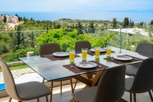 a dining room table with chairs and a view of the ocean at Goudis Villa Thanasis in Lefkada