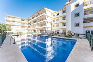 a swimming pool in front of a building at 234 Parque playa La cala in La Cala de Mijas
