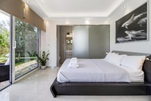 a bedroom with a large bed and a large window at Goudis Villa Thanasis in Lefkada +24 photos