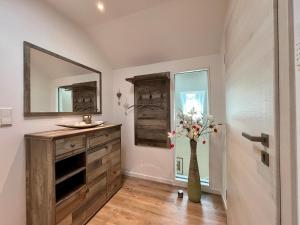 a bathroom with a wooden dresser and a mirror at Ferienwohnung Klosterblick in Öhningen +25 photos