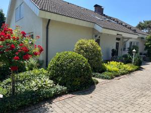 a house with flowering bushes and a brick driveway at Ferienwohnung Klosterblick in Öhningen
