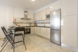 a kitchen with white cabinets and a stainless steel refrigerator at Apartamento Rolycar 202 in Icod de los Vinos