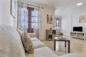 a white living room with a couch and a table at Apartamento Rolycar 202 in Icod de los Vinos