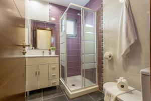 a bathroom with a shower and a toilet and a sink at Apartamento Rolycar 202 in Icod de los Vinos +13 photos