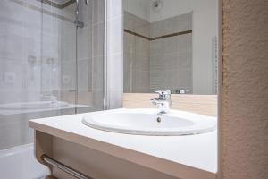 a bathroom with a white sink and a shower at Appartement Ski Valmeinier in Valmeinier +16 photos
