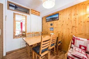 a dining room with a wooden table and chairs at Appartement Ski Valmeinier in Valmeinier