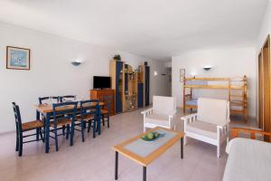 a living room with a table and chairs and a bed at Casa Néctar in Armação de Pêra