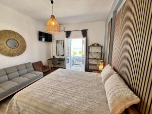 a bedroom with a large bed and a couch at aeolian blu 7 in Parikia