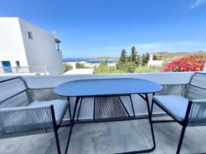 a table and chairs on a balcony with a view of the ocean at aeolian blu 7 in Parikia