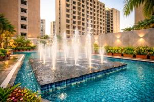 a fountain in the middle of a pool with buildings at The Weekend Address Managed By Stayzy in Dumas