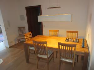 a wooden dining room table with six chairs at Ferienwohnung Kreuzbühl in Albstadt +4 photos