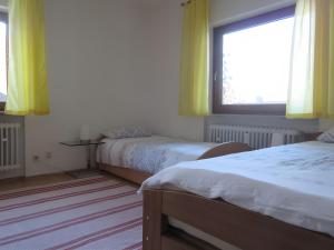 a bedroom with two beds and a window with yellow curtains at Ferienwohnung Kreuzbühl in Albstadt