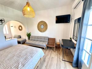 a bedroom with a bed and a couch and a tv at aeolian blu 7 in Parikia