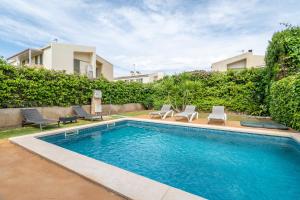 a swimming pool with two chairs and a house at Astur - Moderno Chalet Con Piscina in Puigderrós