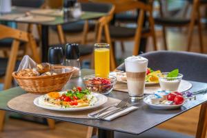a table with plates of food and two glasses of beer at Ambient Hotel & Thermal Spa in Sikonda