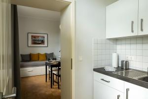a kitchen with white cabinets and a table with a couch at Ferienwohnung Lindner 1 in Weimar +4 photos