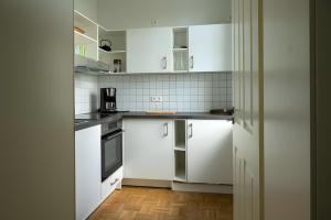a white kitchen with white cabinets and appliances at Ferienwohnung Lindner 1 in Weimar