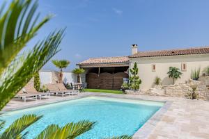 a swimming pool in front of a house at Maison Les Marronniers in Montagne